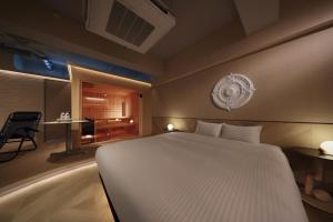 a bedroom with a large white bed and a desk at クリスタルサウナ in Miyako-jima