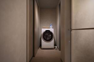 a bathroom with a washing machine in a hallway at クリスタルサウナ in Miyako-jima +8 photos