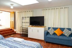 a living room with a blue couch and a flat screen tv at Nice Apartment in Urubamba in Urubamba