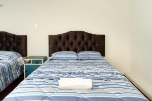 a bedroom with a bed with a blue and white comforter at Nice Apartment in Urubamba in Urubamba
