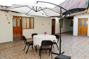 a table and chairs under a white umbrella at Nice Apartment in Urubamba in Urubamba
