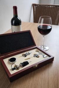 a bottle of wine and a box of glasses and a wine glass at Casa Nova com 3 quartos in São Gabriel