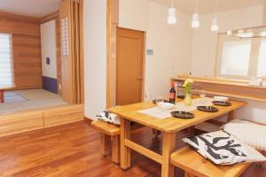 a kitchen with a wooden table and a dining room at 民泊八のや in Hachioji +28 photos