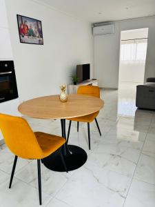 a wooden table and chairs in a living room at Golden DREAM Suites cocon modern in Capesterre-Belle-Eau