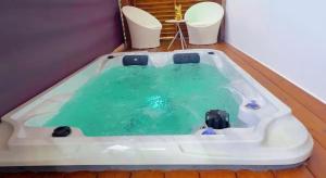 a bath tub filled with green water in a room at Golden DREAM Suites cocon modern in Capesterre-Belle-Eau