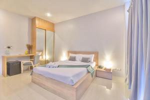 a bedroom with a bed and a desk in it at Lemonade Phuket Hotel -SHA Plus in Chalong