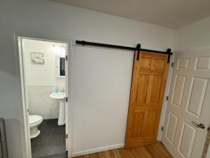 a bathroom with a toilet and a sliding door at Bright & Comfortable Home in the Heart of It All in Central Islip +14 photos