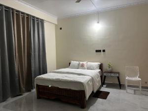 a bedroom with a bed and a table and a chair at Janaa Residence in Dithur