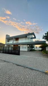 a large building with a fence in front of it at Esplendor Residence Seu Paraíso em Atlântida com Piscina in Xangri-lá