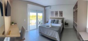 a bedroom with a bed and a balcony at Esplendor Residence Seu Paraíso em Atlântida com Piscina in Xangri-lá +60 photos