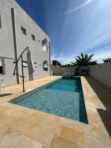 a swimming pool in front of a building at Esplendor Residence Seu Paraíso em Atlântida com Piscina in Xangri-lá