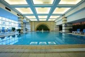 a large swimming pool in a building with a ceiling at The Presidential Beijing in Beijing