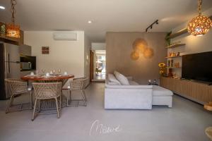 a living room with a couch and a table with chairs at Naay - Sun 008 in Pôrto de Pedras