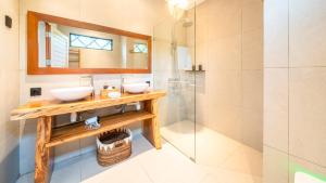 a bathroom with two sinks and a glass shower at Sea Sun Beach Villa in Nusa Lembongan