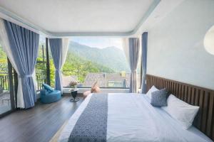 a bedroom with a large bed with a large window at Mây Trắng Homestay in Tam Ðảo