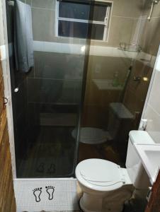 a small bathroom with a toilet and a shower at Chalés FRONT LAKE 1 in Córrego do Bom Jesus
