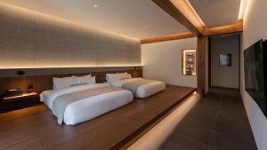 two beds in a hotel room with two bedsvisor at Mungyeong Sadamjae Stay in Mungyeong +49 photos
