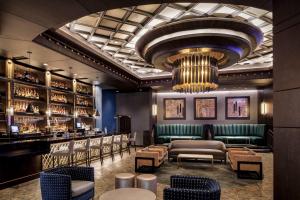 a bar with a green couch and chairs and a chandelier at Choctaw Casino & Resort Durant, a Wyndham Grand Hotel in Durant