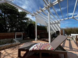 a patio with a pergola and a chair on a deck at saunalu in Kido