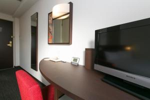 a large flat screen tv sitting on top of a wooden table at Urban Hotel Kyoto in Kyoto