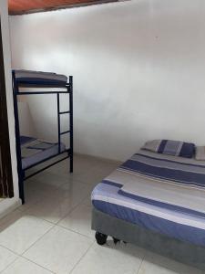 a small bedroom with a bed and a shelf at Hostal Sur Tosc in Cali
