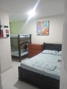 a bedroom with two beds and a dresser in it at Hostal Sur Tosc in Cali