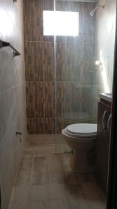 a bathroom with a toilet and a glass shower at Hostal Sur Tosc in Cali