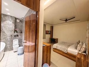 a bedroom with a bed and a bathroom with a shower at Landlord Premier in Rohtak
