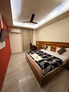 a hotel room with a bed and a ceiling fan at Landlord Premier in Rohtak