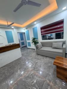 a living room with a couch and a ceiling fan at Landlord Premier in Rohtak