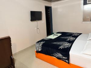 a bedroom with a bed and a tv on the wall at Landlord Premier in Rohtak