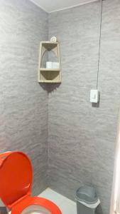 a bathroom with a red toilet and a light at Hammocks - Hamacas in Ríohacha