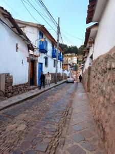 a cobblestone street in a town with buildings at Cusco Center Apartment in Cusco