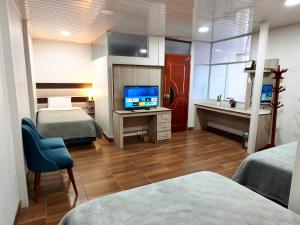 a hotel room with two beds and a television at Cusco Center Apartment in Cusco