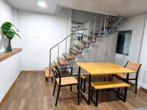 a dining room with a table and chairs and a staircase at Cusco Center Apartment in Cusco +16 photos