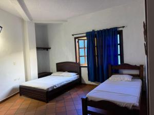 two beds in a room with a window at Hotel Campestre Lucila in Estación El Salto