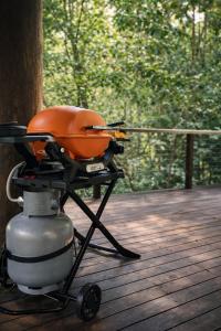 a grill sitting on a deck next to a tree at Firefly in Diwan +9 photos