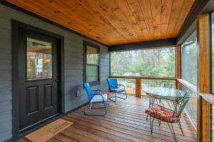 a screened porch with a glass table and chairs on it at Roam Inn in Black Mountain
