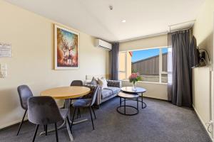 a living room with a table and a couch at Daffodil Apartments in Christchurch