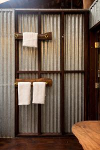 a bathroom with white towels hanging on a wall at Firefly in Diwan