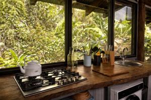 a kitchen with a stove and a large window at Firefly in Diwan