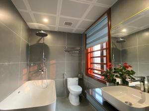 a bathroom with a tub and a toilet and a sink at Champs De Tam Coc Hotel in Vũ Lâm +33 photos