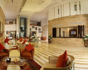 eine Lobby mit Sofas und Stühlen sowie einem TV in der Unterkunft Best Western Plus Fursan in Riad