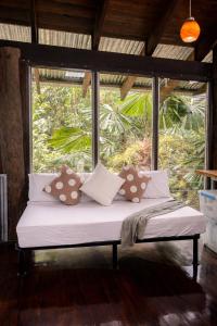 a bed in a room with a large window at Firefly in Diwan