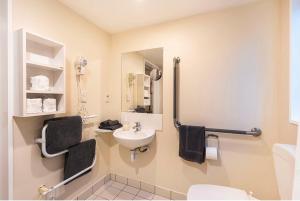 a bathroom with a sink and a toilet at Daffodil Apartments in Christchurch