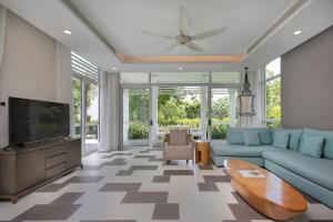 a living room with a blue couch and a tv at Premier Villa Resort Danang in Danang