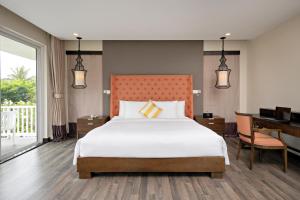 a bedroom with a large bed and a desk and a bed sidx sidx at Premier Villa Resort Danang in Danang