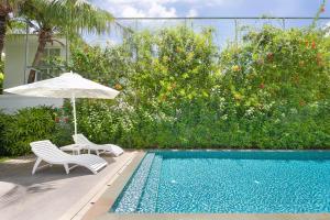 a swimming pool with two chairs and an umbrella next to at Premier Villa Resort Danang in Danang +15 photos