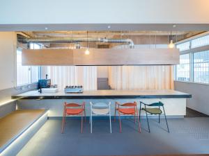 a kitchen with three chairs and a counter at SMIRE STAY Ishigaki in Ishigaki Island