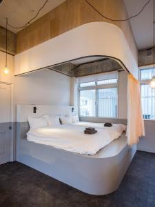 a large white bed in a room with windows at SMIRE STAY Ishigaki in Ishigaki Island +57 photos
